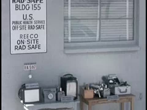 An interior laboratory wall with a sign reading 'Reeco Rad Safe' and monitoring equipment