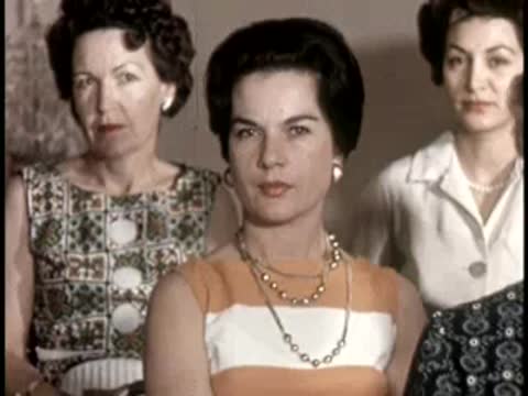 Three women stand together looking forward, vintage fashion and hairstyles