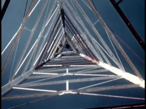 Looking straight up inside a tall industrial tower structure, engineering details