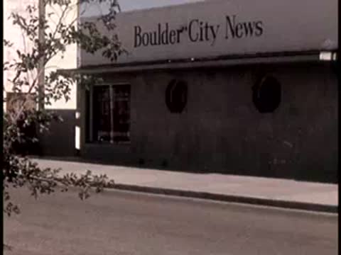 Exterior view of the Boulder City News building, then a radio tower outside