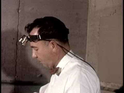 Profile view of a man looking down while wearing a headset, retro equipment