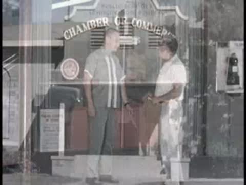 men leaving Chamber of Commerce and walking outside a public administration building