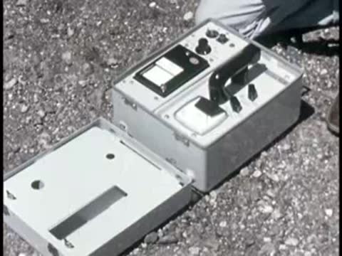 open metal case containing instruments and colored compartments on the ground