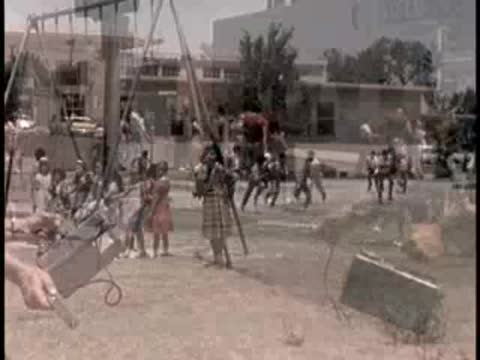 archive footage shows children playing near school and people walking outside