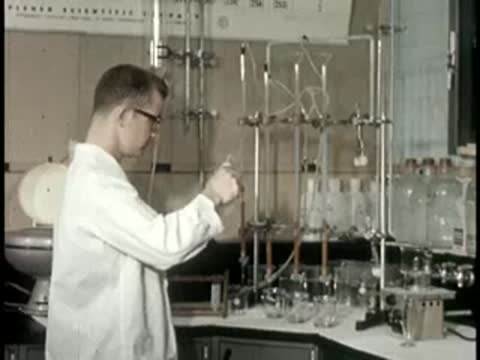 worker in white coat working with complex chemistry apparatus