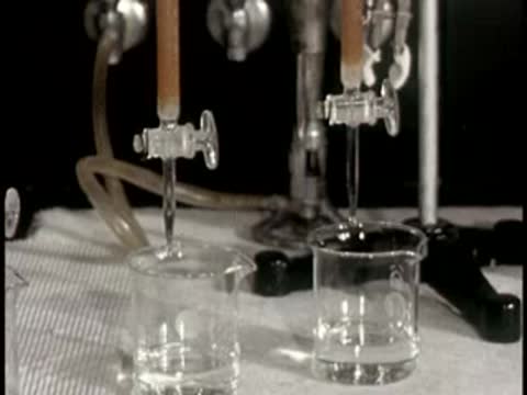 laboratory chemistry equipment dripping liquid into glass beaker setup