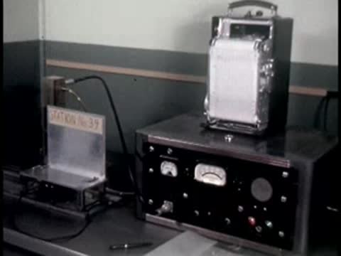 A paper chart rolls through a mechanical recording device in a laboratory setting.