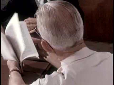 A person reading a manual titled 'Ionizing Radiation' with tables and diagrams