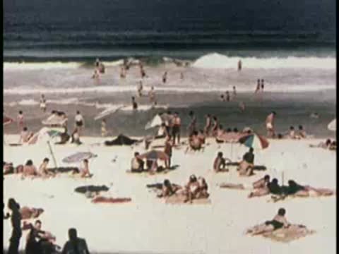 Panoramic view of a bustling sandy beach with waves rolling ashore.
