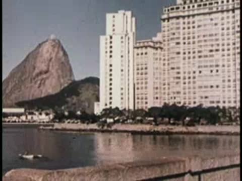 Scenic view of a body of water with buildings and mountain background.