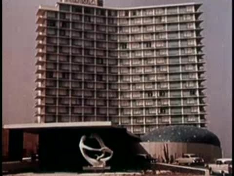 Modern hotel building with distinctive curved balconies against clear sky.