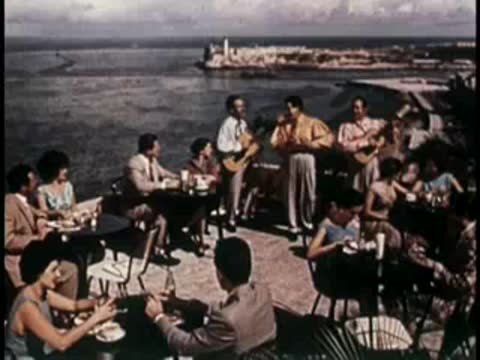 Outdoor café scene with people dining by the waterfront.