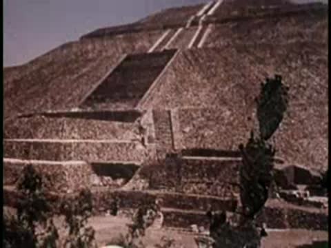 Ancient stone pyramid structure with a staircase under clear sky.