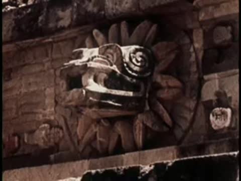 Detailed stone carving of an ornate face on a historical structure.