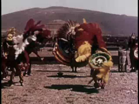 Group of traditional dancers performing in an open dusty area.