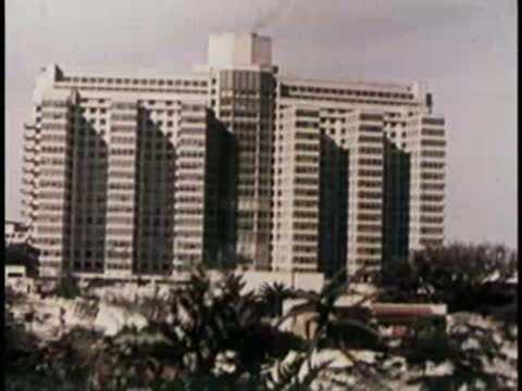Modern multi-story apartment building with geometric concrete facade in city.