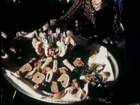 A large platter of seafood and appetizers served on a table, 1950s.
