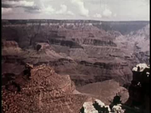panoramic view of a vast, layered canyon landscape under an open sky