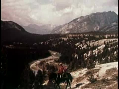 river winding through a lush mountain valley with a person riding a horse