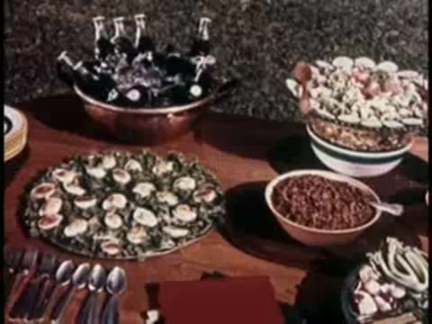 spread of food including salads, casseroles, and platters on a wooden table outdoors